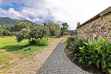 View of the ruins of the fortress wall against the background of green grass, flowers and blue sky. Batumi, Georgia.  
