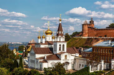 Fototapeta na wymiar View of the Church of the Holy Prophet of God Elijah, the Kremlin wall with a tower and urban development. Nizhny Novgorod, Russia