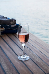 A glass of champagne is on the ship's wooden deck. Evening walk across the lake.