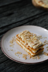 Food in a restaurant: a plate with a sweet dessert, a piece of cake on the wooden table