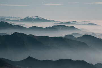 Fototapeta premium misty layers of mountains in the morning at sunrise