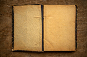An open old book with yellowed pages on the table. An old encyclopedia with blank pages in vintage style.