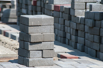 Blocks of building tiles of gray color are on the street. Theme of building construction.