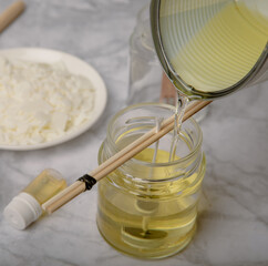 Pouring melted wax into a candle blank. Handmade soy candles. Utensils for making candles. Handmade with love. Cruelty free vegan product. Hobby. aroma candles.
