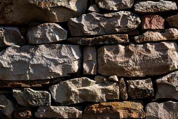 Texture stone wall lined with mountain stones, texture stone background, brown stones.