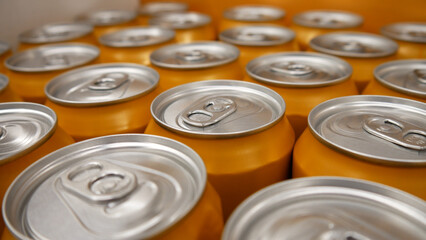 Close-up of many orange cans with soda or beer