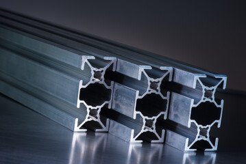 Aluminum exstrusion profile on gray background, component of metalurgy industry