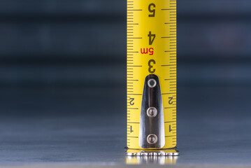 Metal tape measure on metal workshop table macro view