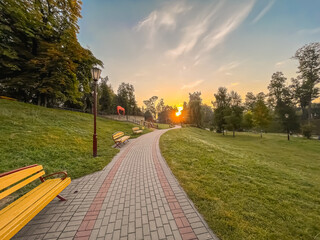 Asphalt path with benches in Zhiliber's park at dawn in the morning. Grodno. Belarus