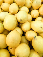 Ripe Yellow Lemons Close-Up Background Or Texture. Harvest Lemons, Lots of Yellow Lemons. Vitamin C. vertical photo