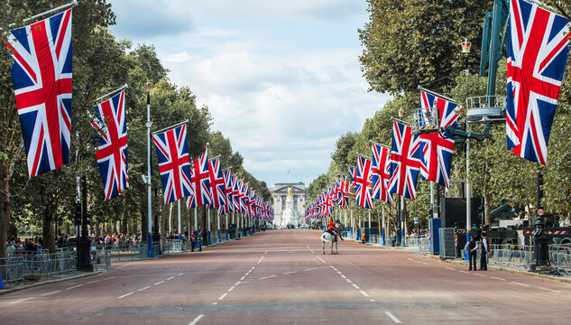 London, UK. The last way of the Queen Elizabeth II. Pall Mall decorated with British flags for funeral ceremony. Horse guard on duty