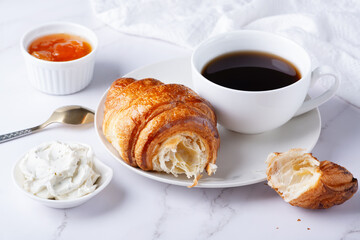 Fresh sweet croissants with cottage cheese and apricot jam for breakfast. Continental breakfast on a white table