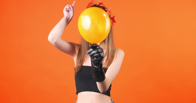A girl with Halloween corpse make-up returns to the camera with a balloon in her hand that breaks it.
