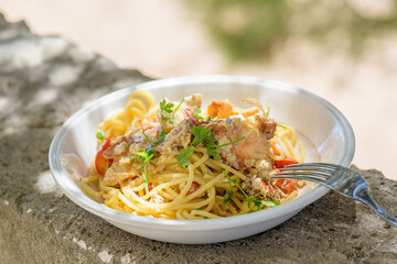 Fresh cooked spaghetti with edible brown sea crab also known as Cancer Pagurus by Mediterranean Sea on white plate on concrete grey background, close up