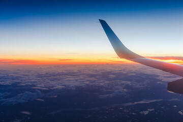 Obraz premium Wing of an airplane in the sunset