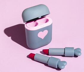 red lipstick in a cute gray case on a pink background with hard shadows