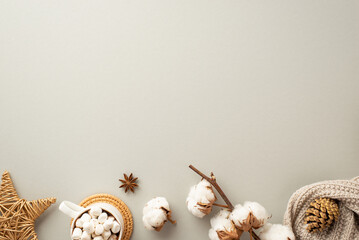 Top view photo of cup of hot chocolate with marshmallow on rattan placemat knitted scarf wicker star ornament anise pine cone and cotton branch on isolated pastel grey background with empty space