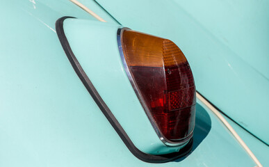 The tail light of a vintage retro car. Retro car brake light. The rear fender of a vintage car is...