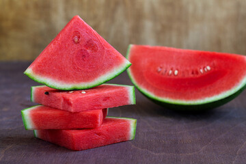 slices of fresh red watermelon. stack of Watermelon slices on the brown wooden table. copy space