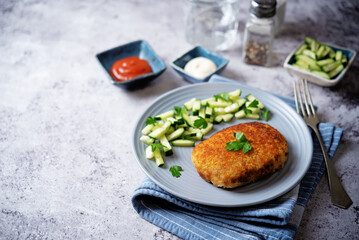 Fresh prepared schnitzel in a plate with fresh cucumber slices