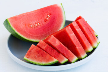 grey plate with slices of fresh watermelon. red Watermelon slices on the white table with copy...