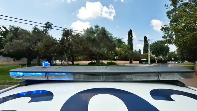 POV shot of a Police car with blue and red lights driving fast through city streets