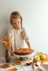 Little Girl in White Dress Standing in Kitchen with Apple Pie Autumn Concept Fall