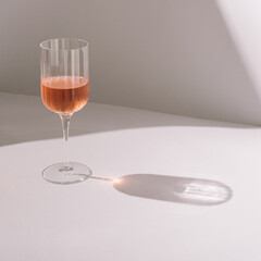 Glass of rose  wine isolated on light grey background.