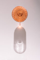 Glass of rose wine  isolated on liht grey background from top view.