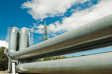 pipeline and power lines on the background of blue sky and clouds