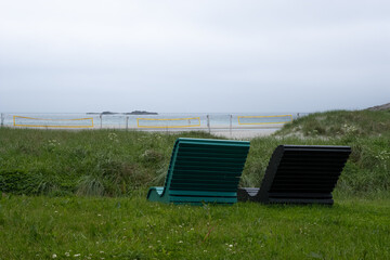 Wonderful landscapes in Norway. Colorful chairs on the beach.  Cloudy day. Selective focus