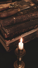 old books on the table, reading by candlelight, magnifier	