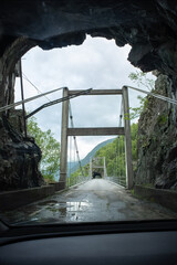 Kyrping, Norway - June 9, 2022: the old Akra Fjord road, POV from a Tesla Model 3 driving on the scenic route. Tunnel and bridges in a cloudy spring day. Selective focus