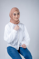 Portrait of a beautiful female Muslim model wearing hijab, a lifestyle apparel for Muslim women isolated on white background. Modern hijab fashion concept.