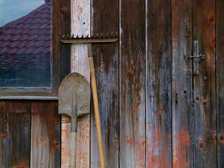 Agriculture tools with aged window and door at rural home (barn)  wall
