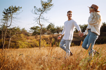 Young couple resting in nature. Autumn weather. Relaxation, youth, love, lifestyle concept.