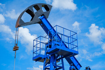 Oil derricks against cloudy sky