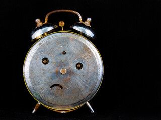 Back of an oOld and analog iron alarm clock in the dark