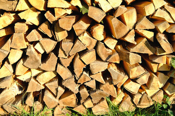 logs of firewood chopped on logs in woodpile, logging for winter, concept stoking stove, fireplace, seasonal cooling in housing, country's economic problems in energy sector, shutdown of Russian gas