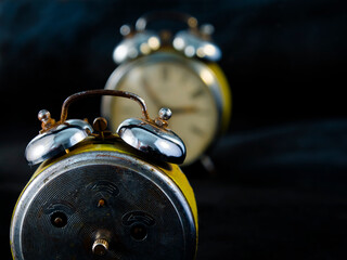 Old and analog iron alarm clock in the dark