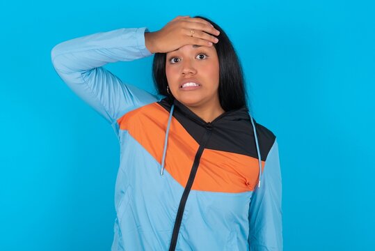 Oops, What Did I Do? Young Beautiful Latin Woman Wearing Sportswear Holding Hand On Forehead With Frightened And Regret Expression.