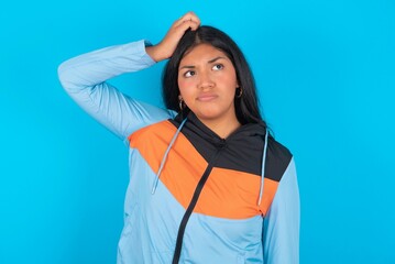 young beautiful latin woman wearing sportswear saying: Oops, what did I do? Holding hand on head...