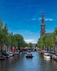 city canal in Amsterdam with boat and church