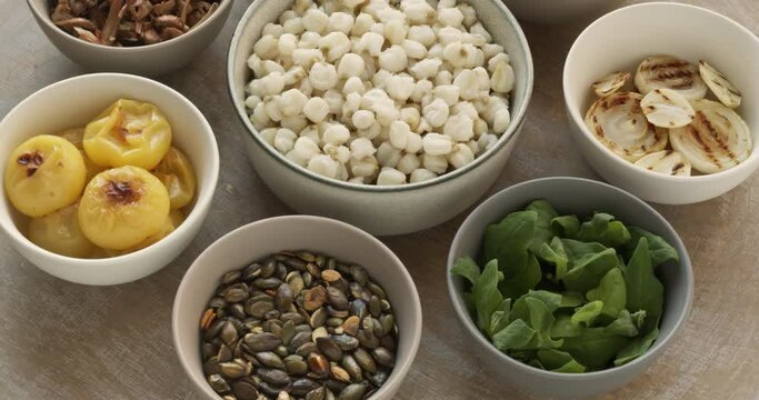 Ingredients for pozole verde soup: hominy, New Zealand spinach, roasted pumpkin seeds, roasted white onion, roasted poblano pepper, roasted tomatillo, shredded and roasted jackfruit, fried shiitake.