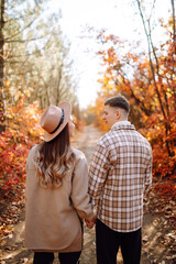 Naklejka premium Young couple in love walking in the park on a autumn day. Enjoying time together.