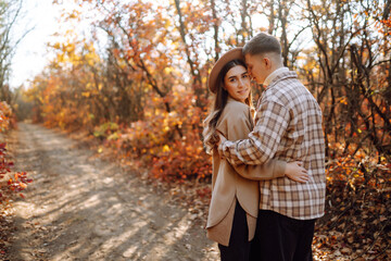 Young couple in love walking in the park on a autumn day. Enjoying time together.