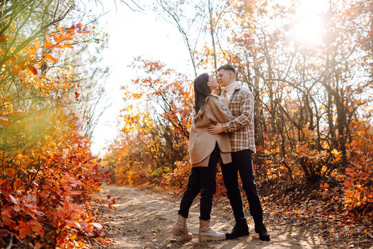 Young couple in love walking in the park on a autumn day. Enjoying time together.