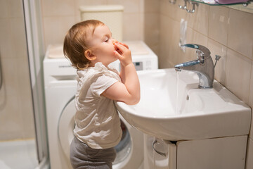 The child independently washes his hands in the bathroom. Prevention of infectious diseases, flu and coronavirus.