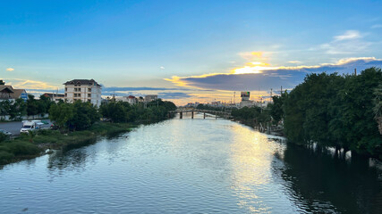 Fototapeta premium The twilight sky and clouds in sunset time from late afternoon above the canal in urban area, Thailand.
