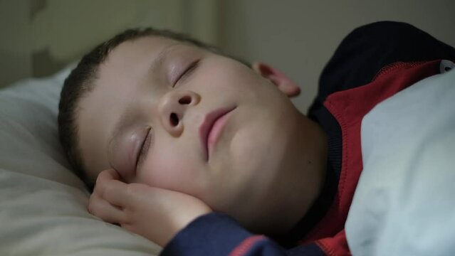 a five-year-old boy sleeps in his crib